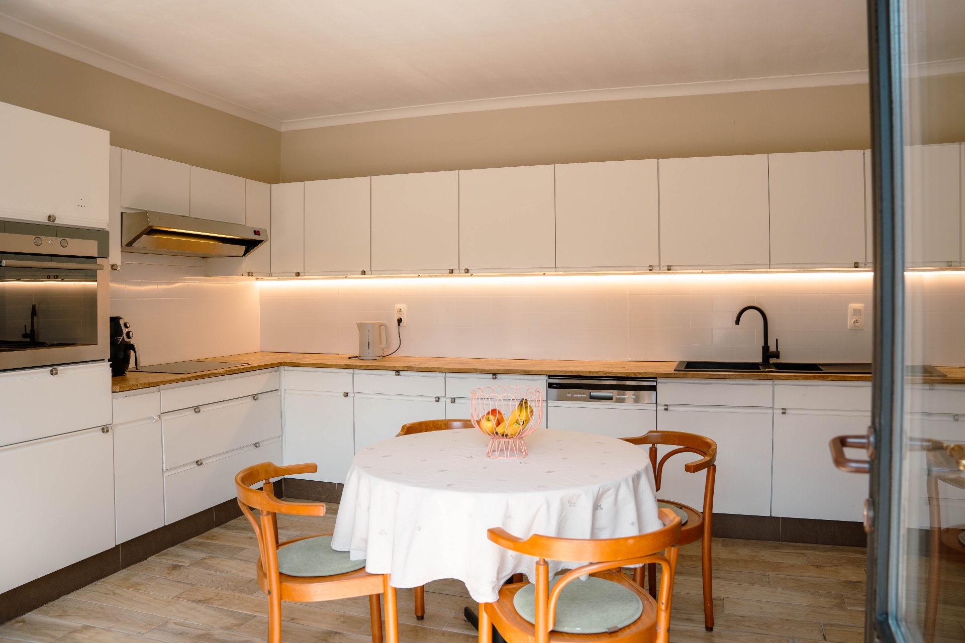 Ruime witte keuken met houten werkblad
